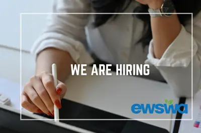 We are hiring. A worker in an office with a computer. The EWSWA logo.