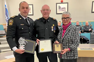 Essex-Windsor EMS Chief Justin Lammers and Warden Hilda MacDonald present retired paramedic Dan Pickel with certificates and a plaque.